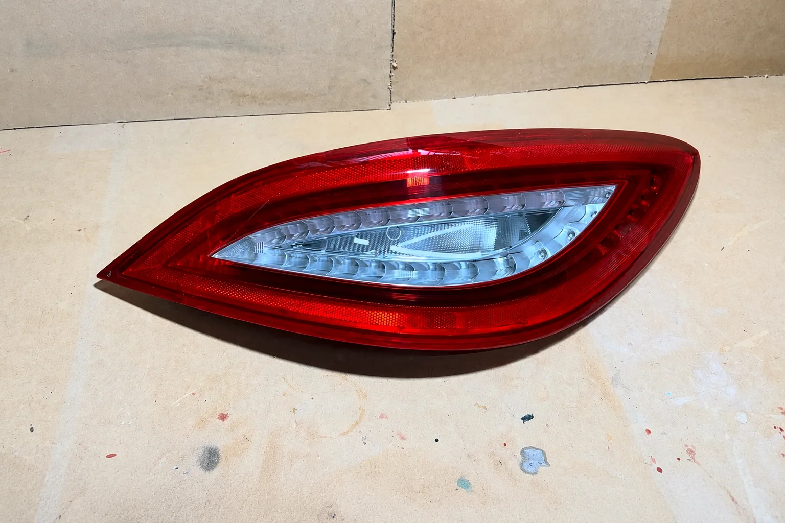 Lanterna traseira Mercedes reparada e pronta na bancada.